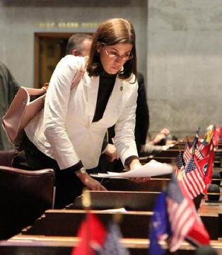 In a Monday, Feb. 7, 2011 photo, state Rep. Julia Hurley gathers her papers on the House floor in Nashville, Tenn. The Lenoir City Republican, in the latest edition of Hooters Magazine, attributes her business and political success to her time working at the restaurant chain known for its waitresses' revealing outfits. 