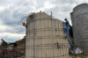 Jordan Baldwin climbs up the side of the partially destroyed silo on his father's farm on Thursday, March 24, 2011. The silo was 70 feet tall before the storm late Wednesday, March 23, 2011, knocked most of it down and tore the roof from the barn.