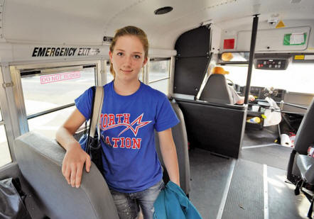 Abigail Howard, 11, poses on Tuesday on the Loudon County school bus that she and her sister, Lauren, 13, ride to North Middle School each day. Audrey Howards daughters make up two of the three riders of the yellow bus that takes them to North Middle, the school theyve transferred to under the federal No Child Left Behind law.